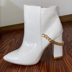 White boot with statement chain